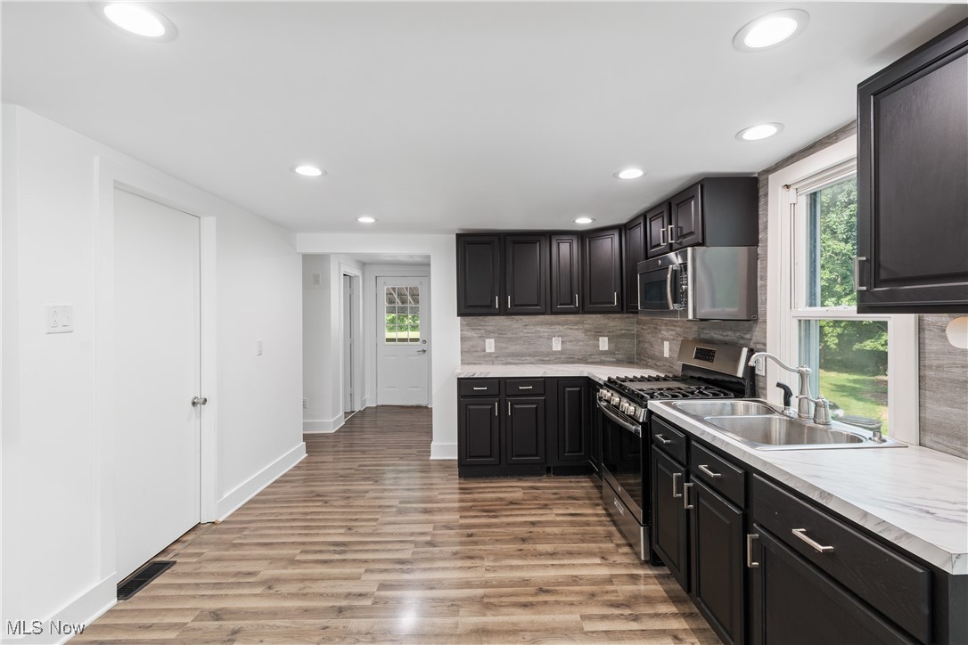 8177 South Cleveland Massillon Road, Unit 55 Clinton, OH 44216 - Photo 9 of 32 Kitchen featuring sink, light hardwood / wood-style flooring, tasteful backsplash, and stainless steel appliances