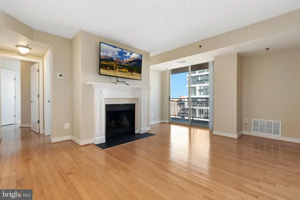 a view of a livingroom with wooden floor and a fireplace