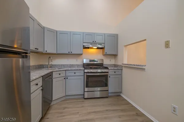 a kitchen with granite countertop a stove and a sink