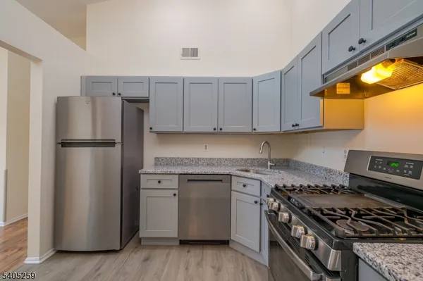 a kitchen with stainless steel appliances granite countertop a stove a refrigerator and a stove