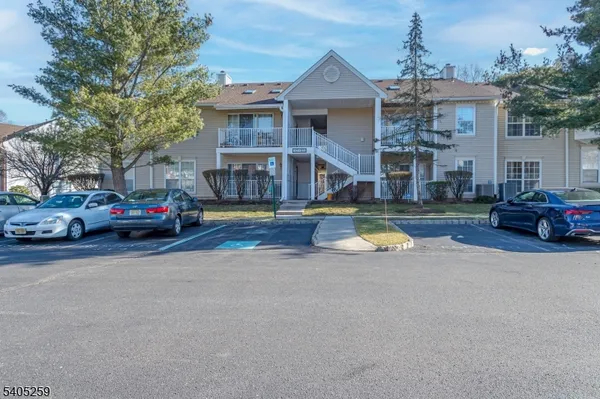 a view of a building with cars park in front of house