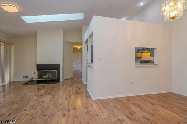 a view of a livingroom with wooden floor and a fireplace