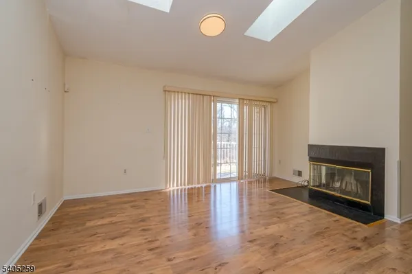 a view of an empty room with a fireplace and a window