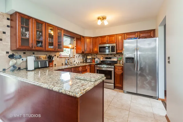 a kitchen with kitchen island granite countertop a sink refrigerator and microwave