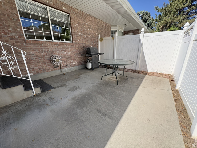 486 West 120 North Orem, UT 84057 - Photo 27 of 30 Private concrete patio area featuring a brick exterior wall and white vinyl fencing