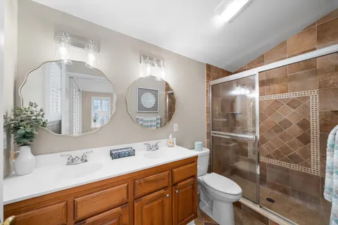 a bathroom with a sink mirror toilet and a shower