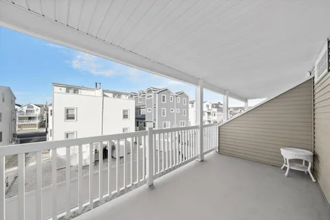 a view of a porch with wooden floor and fence