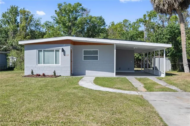 a front view of house with yard and trees