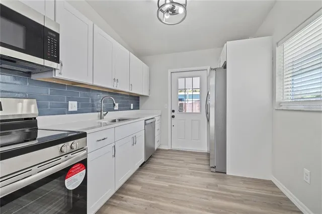 a kitchen with cabinets appliances and a window