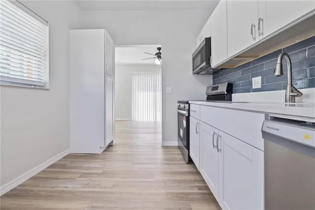 a kitchen with cabinets and wooden floor