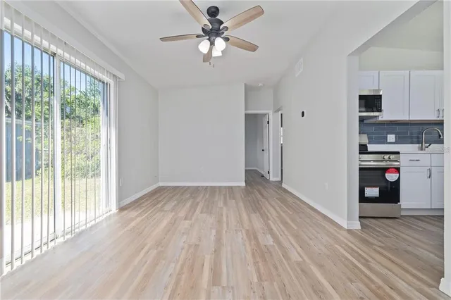 a view of a kitchen with wooden floor and a ceiling fan