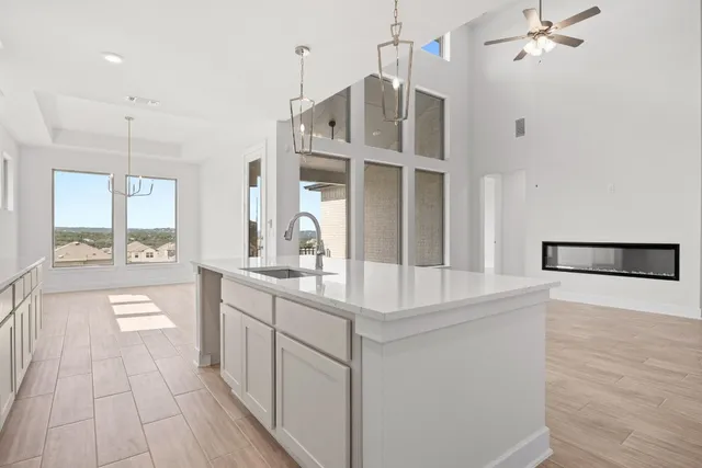 a large kitchen with kitchen island a large counter space a sink appliances and cabinets