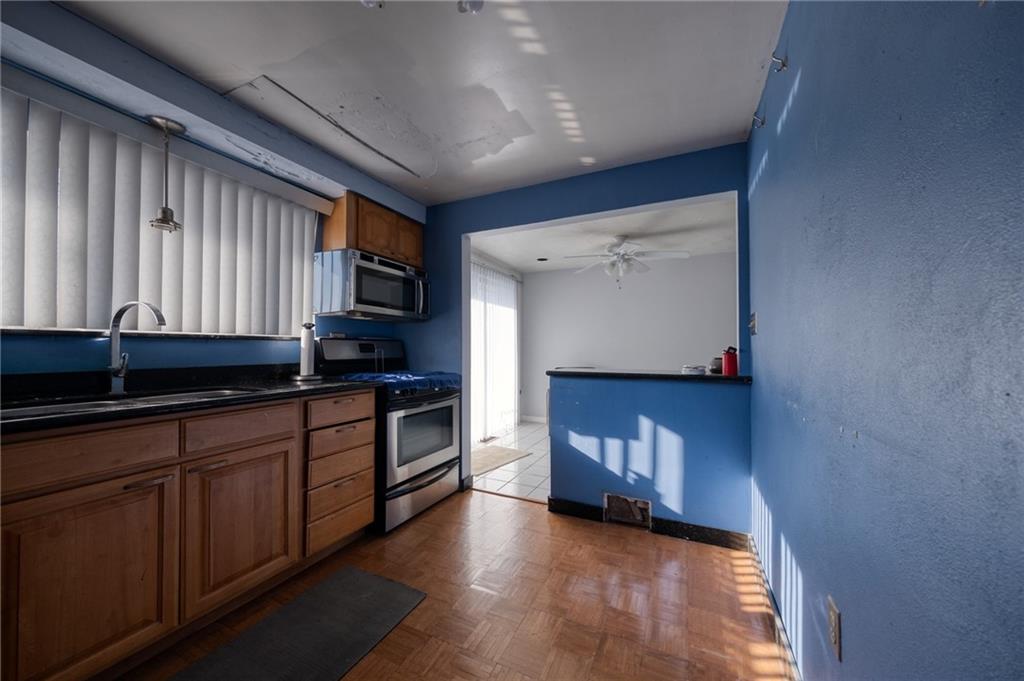 918 Stock Street Pittsburgh, PA 15207 - Photo 6 of 20 a kitchen with stainless steel appliances granite countertop a stove a sink and a microwave