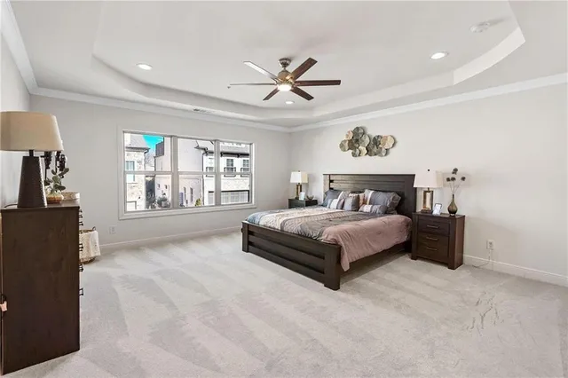 a spacious bedroom with a large bed and a chandelier