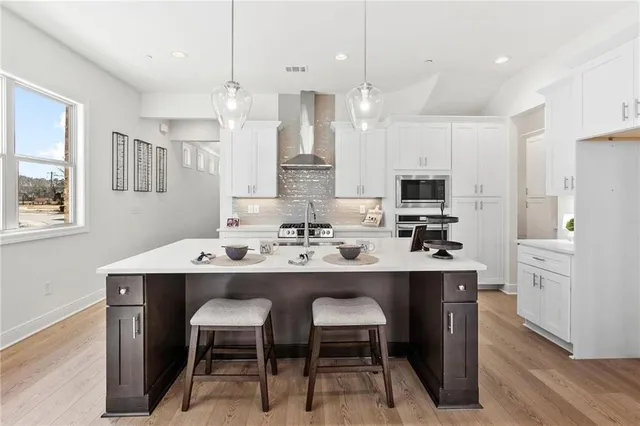 a kitchen with white cabinets and chairs