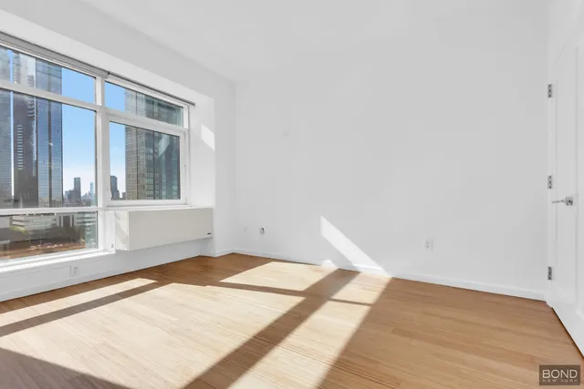 a bedroom with a bed and a large window