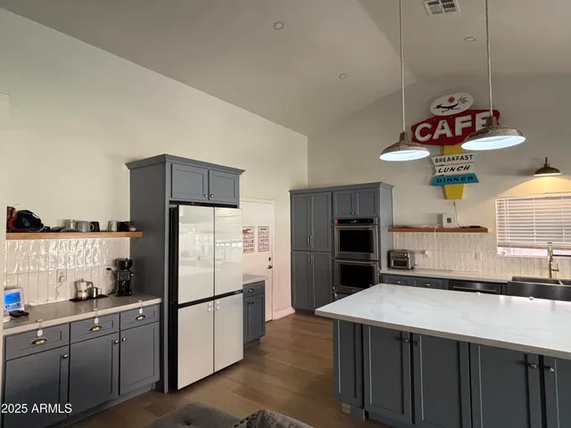 a kitchen with refrigerator a microwave a stove and cabinets