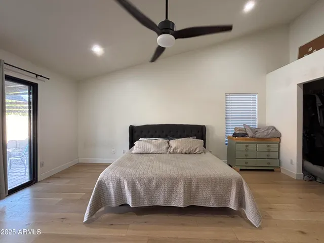 a bedroom with a bed and a flat tv screen on dresser