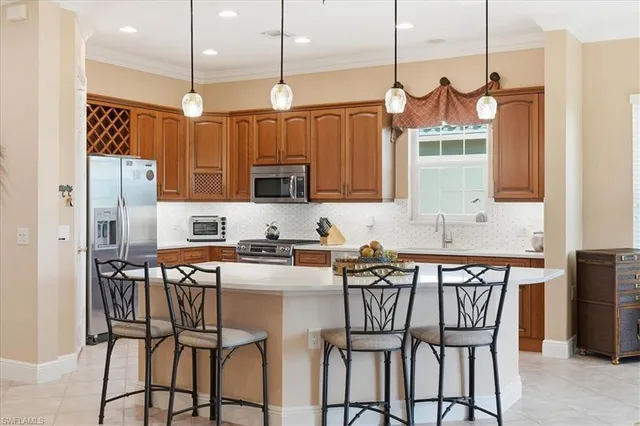a kitchen with stainless steel appliances granite countertop a kitchen island a stove a table and chairs