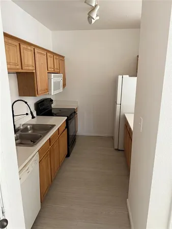 a kitchen with a sink a refrigerator and cabinets