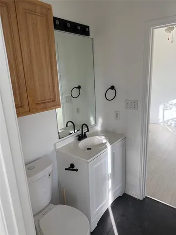 a bathroom with a toilet sink and mirror