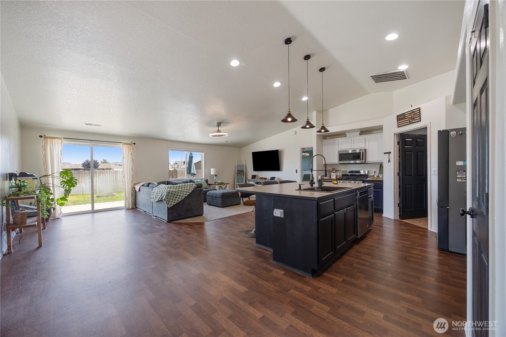 5421 Jackson Lane Pasco, WA 99301 - Photo 13 of 40 a large open kitchen with a refrigerator a oven a dining table and chairs with wooden floor