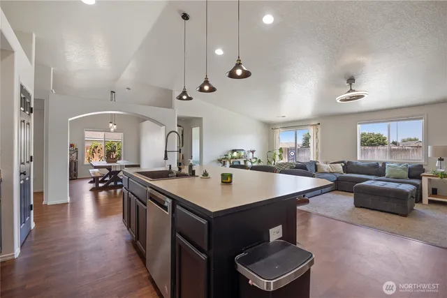 a room with stainless steel appliances lots of wooden furniture