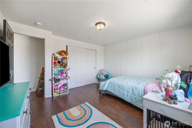 a bedroom with bed and a wooden floor
