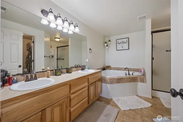 a large bathroom with a double vanity sink mirror and bathtub