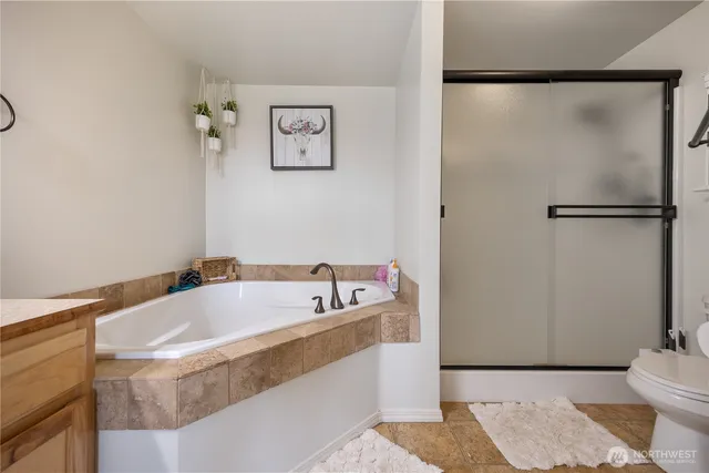 a bath tub sitting next to a white toilet and a shower
