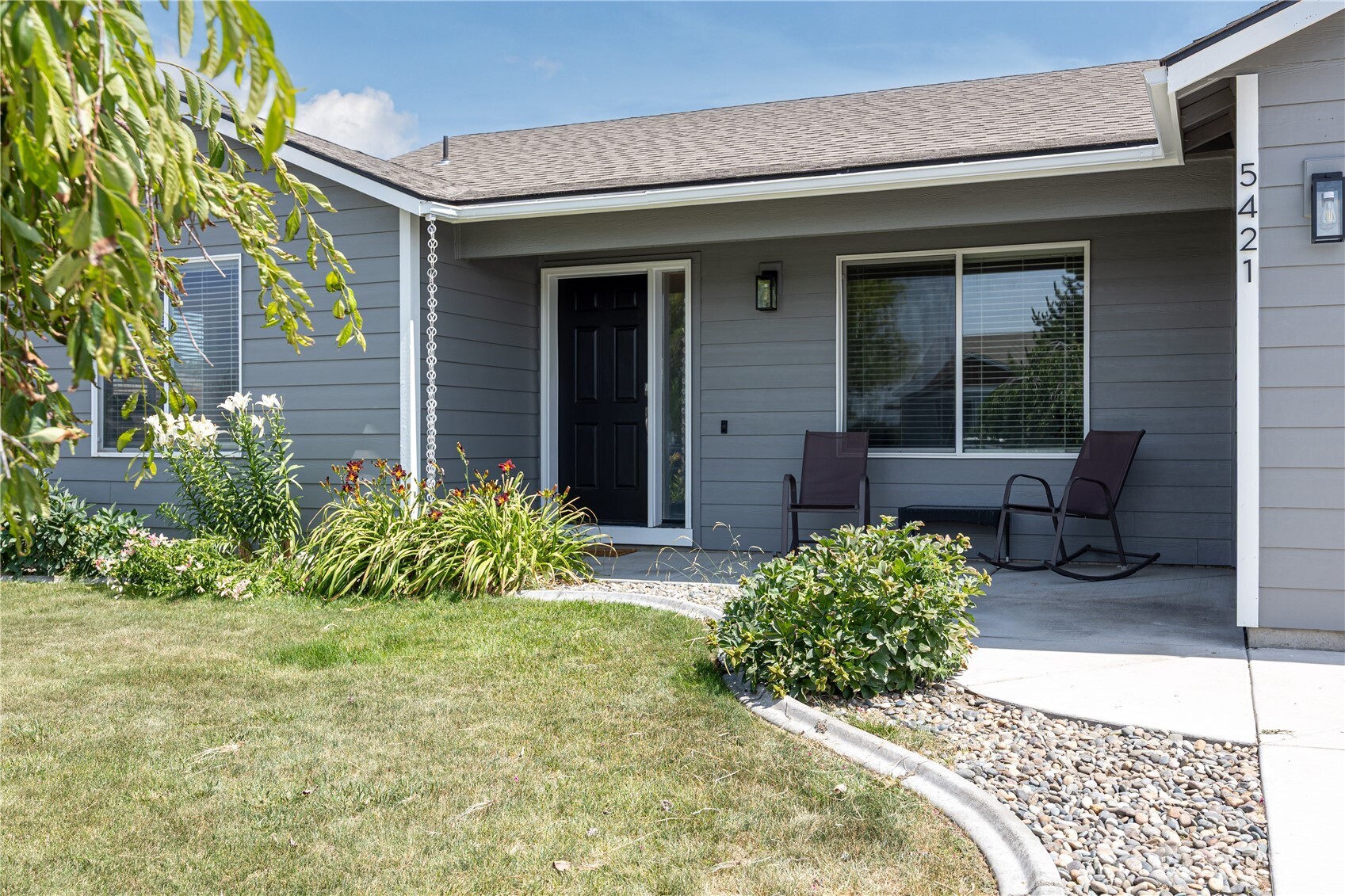 5421 Jackson Lane Pasco, WA 99301 - Photo 3 of 40 a view of a house with potted plants and a bench in front of main door