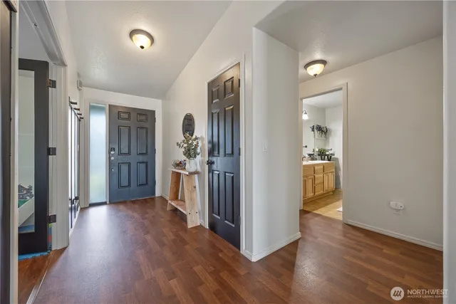 a view of a hallway with wooden floor and a dining room