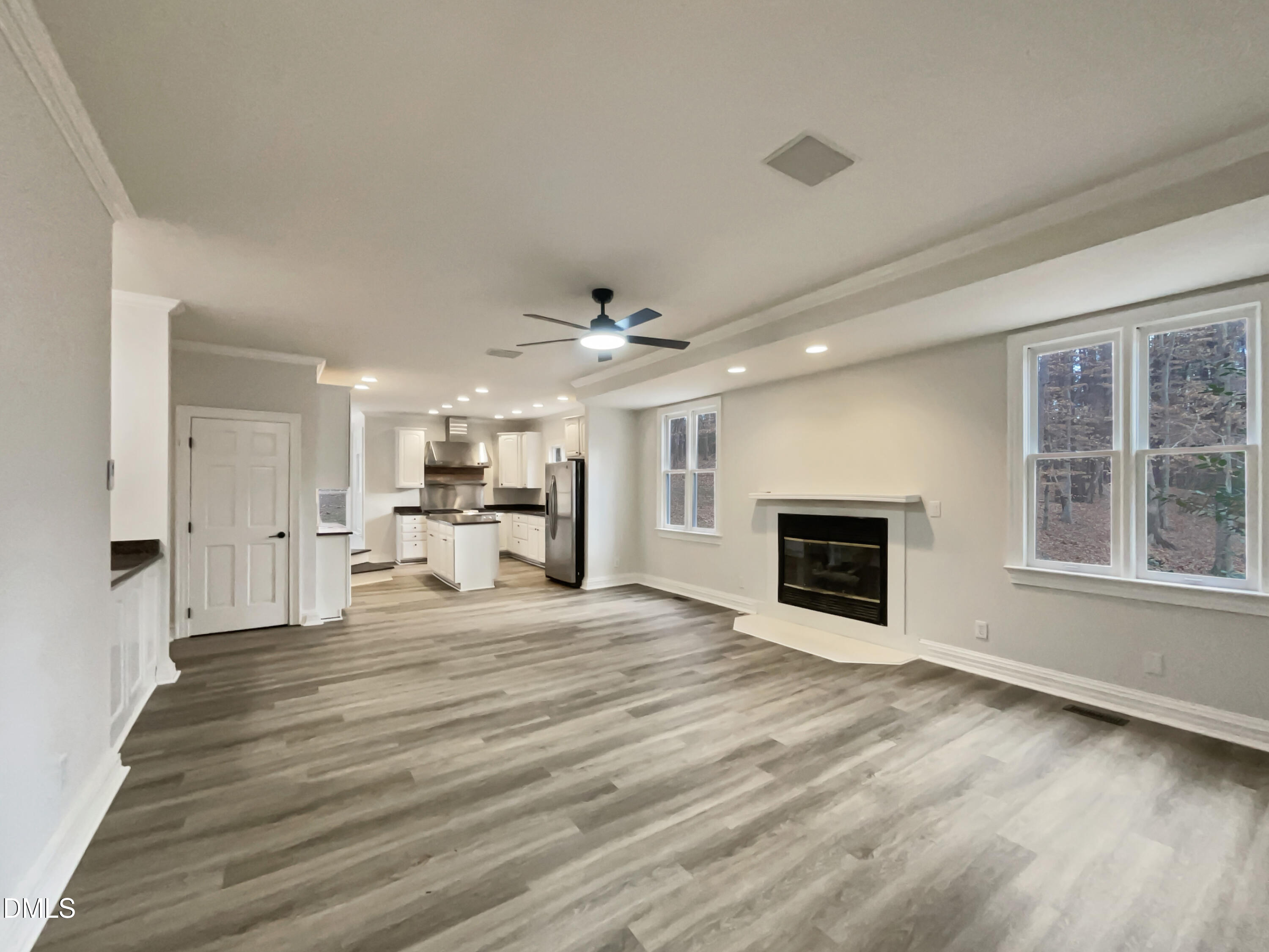 6212 Trevor Court Raleigh, NC 27613 - Photo 3 of 24 a view of a livingroom with a fireplace a ceiling fan and wooden floor