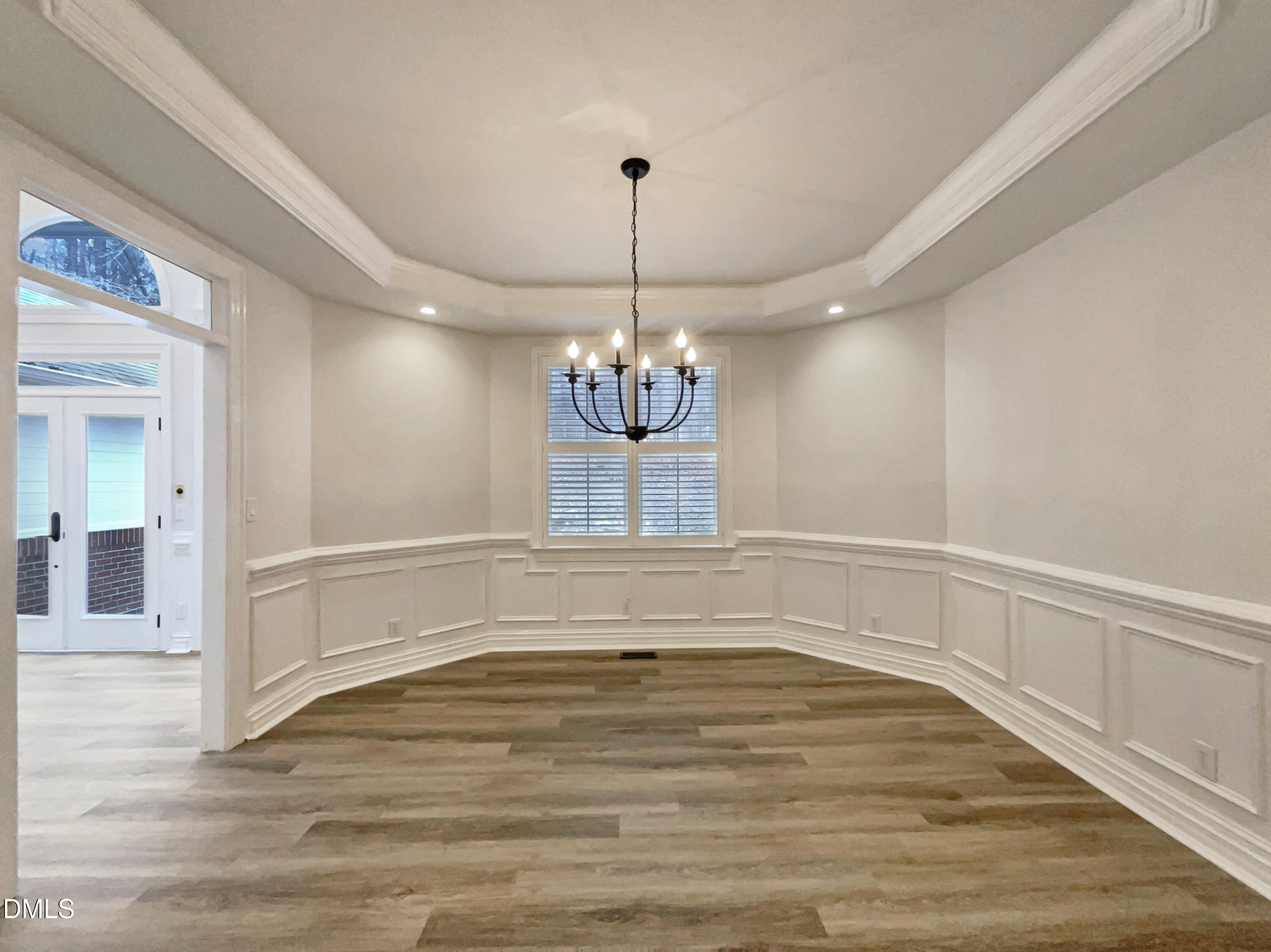 6212 Trevor Court Raleigh, NC 27613 - Photo 10 of 24 a view of an empty room with chandelier and wooden floor
