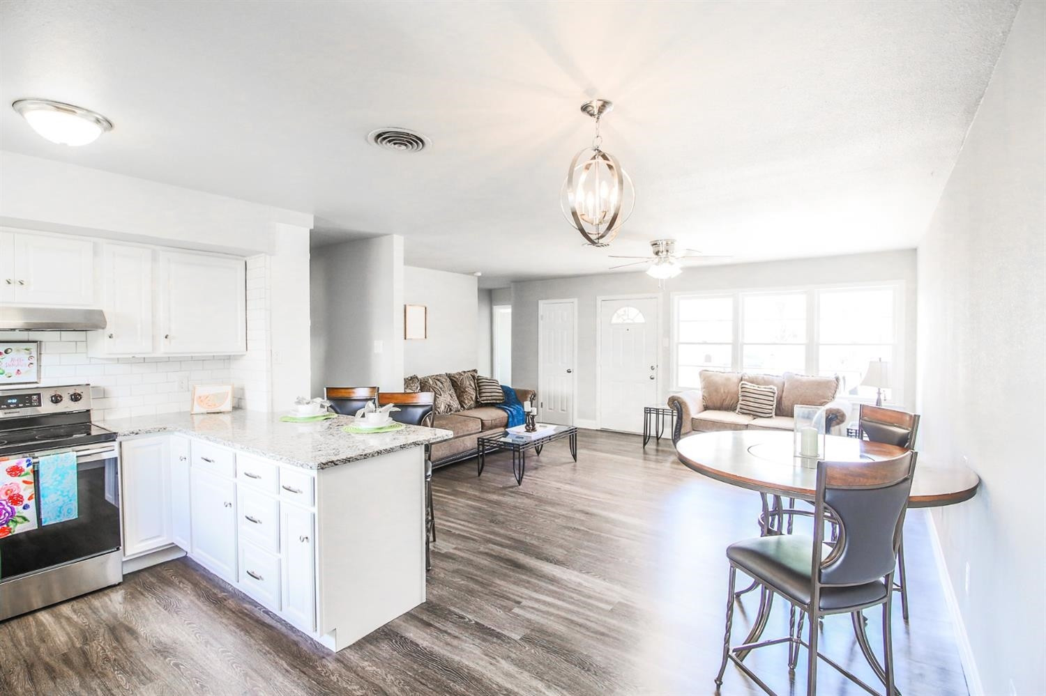 5002 43rd Street Lubbock, TX 79414 - Photo 9 of 10 a open kitchen with stainless steel appliances kitchen island granite countertop a stove a sink dishwasher and white cabinets with wooden floor