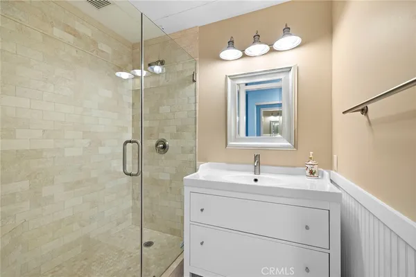 a bathroom with a sink a mirror a vanity and shower