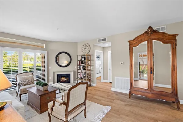 a living room with fireplace furniture and a large window