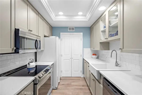 a kitchen with stainless steel appliances a sink stove and cabinets