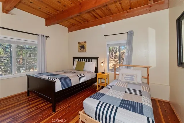 a bedroom with bed and wooden floor