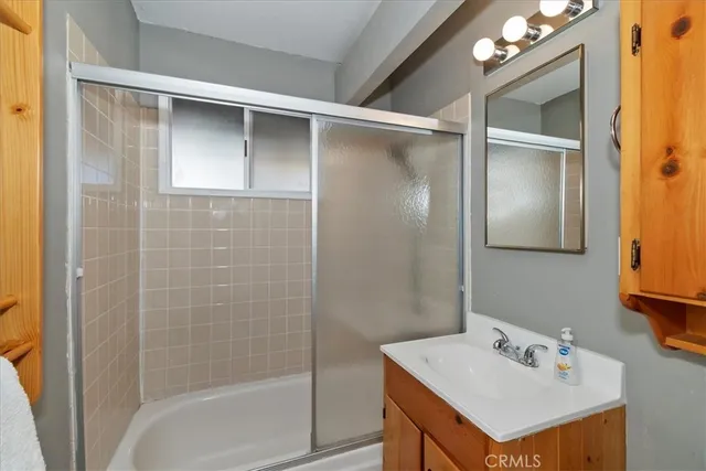 a bathroom with a sink vanity and shower