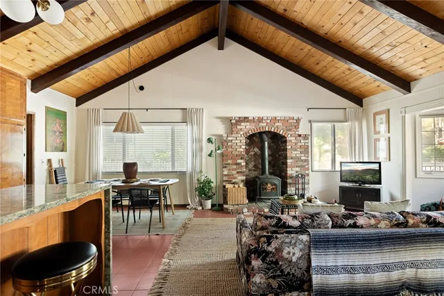 a living room with furniture a fireplace and large windows