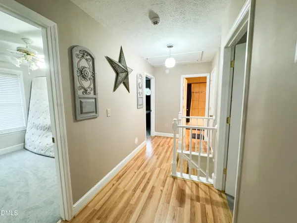 a view of a hallway with wooden floor and staircase
