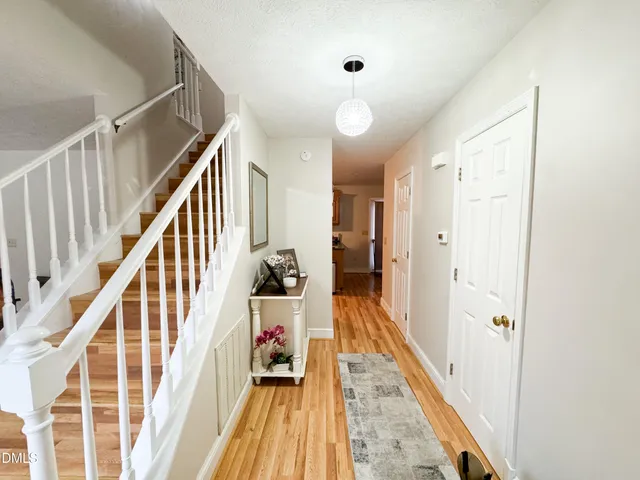 a view of a hallway with wooden floor and staircase