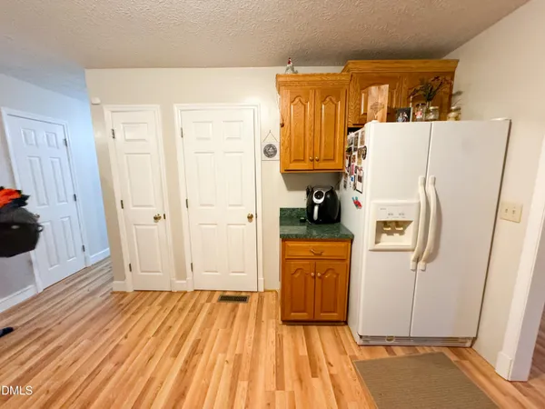 a view of a kitchen with wooden floor and electronic appliances
