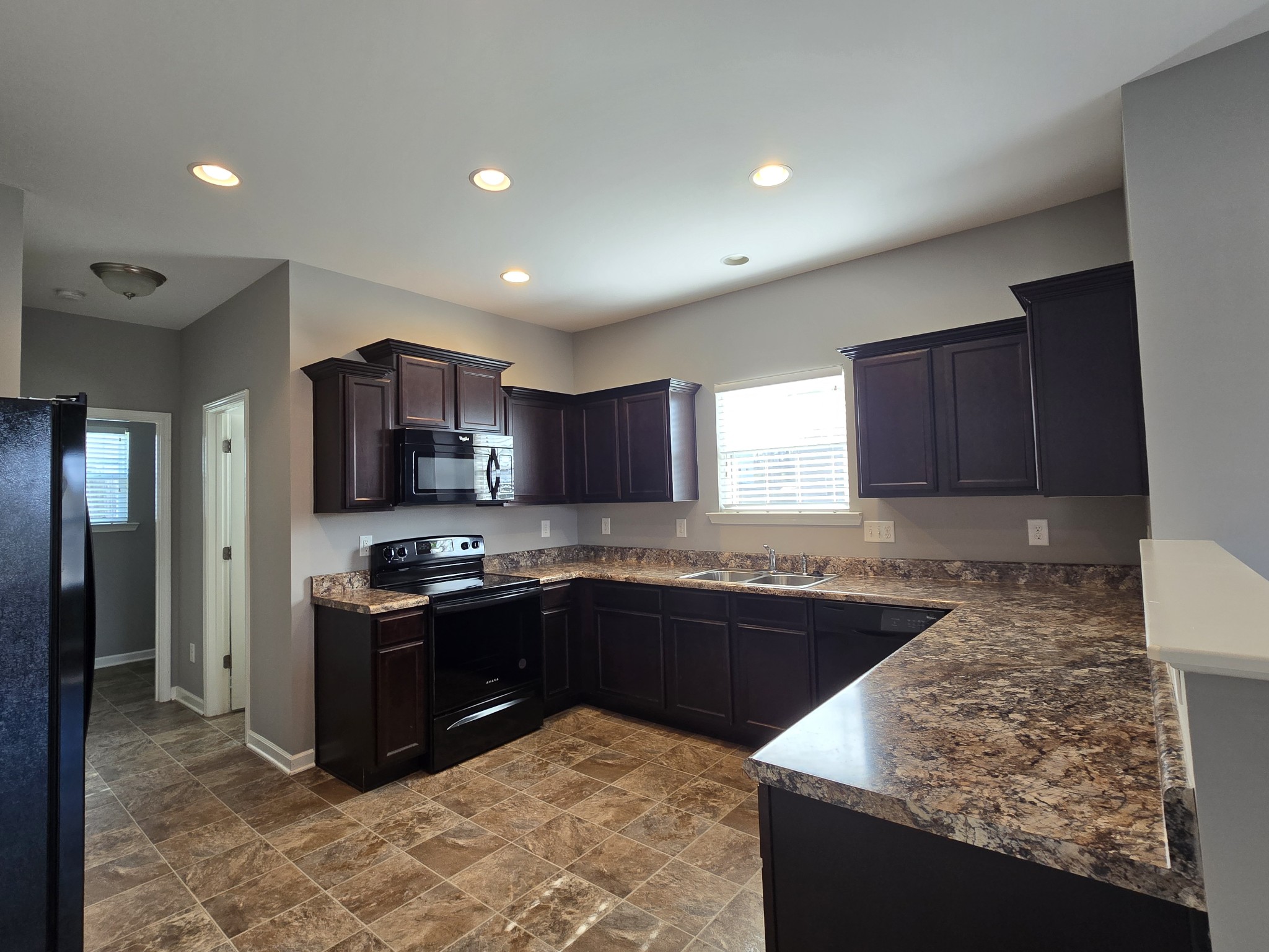 3003 Dove Court Spring Hill, TN 37174 - Photo 6 of 23 a kitchen with stainless steel appliances granite countertop a sink stove and refrigerator