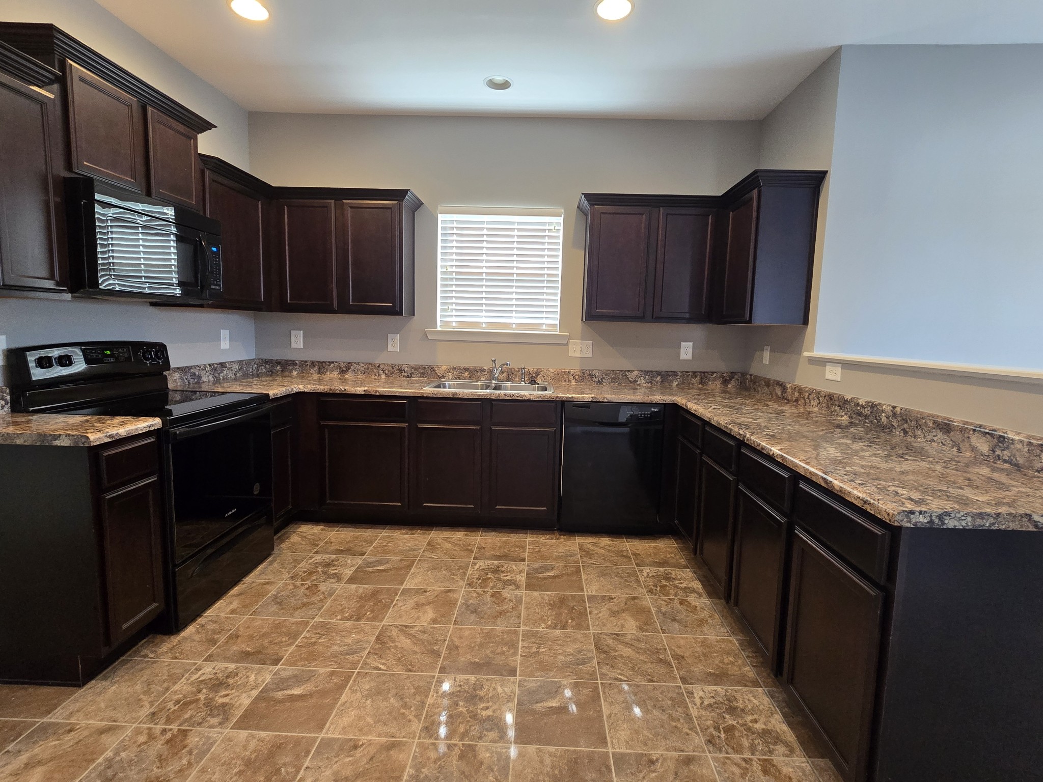 3003 Dove Court Spring Hill, TN 37174 - Photo 7 of 23 a kitchen with stainless steel appliances granite countertop a sink stove and microwave