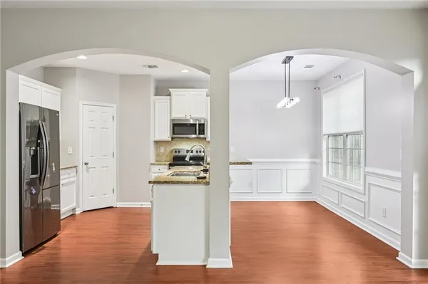 a kitchen with stainless steel appliances a refrigerator and wooden floor