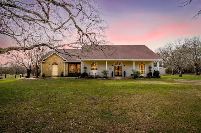 a front view of a house with a yard and trees