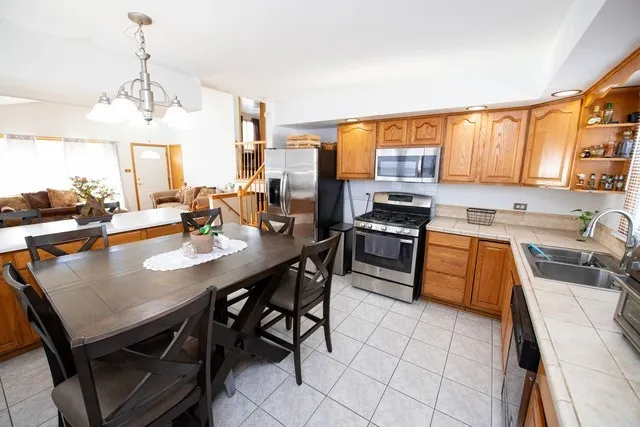 a kitchen with a stove a sink a dining table and chairs