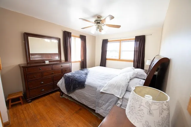 a bedroom with a bed window and dresser